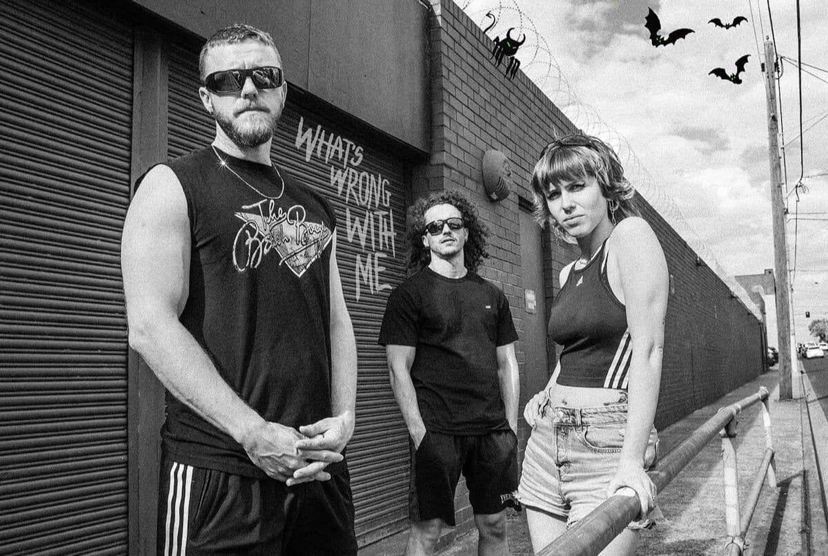 A band poses together in front of a garage door, showcasing their unique style and camaraderie.