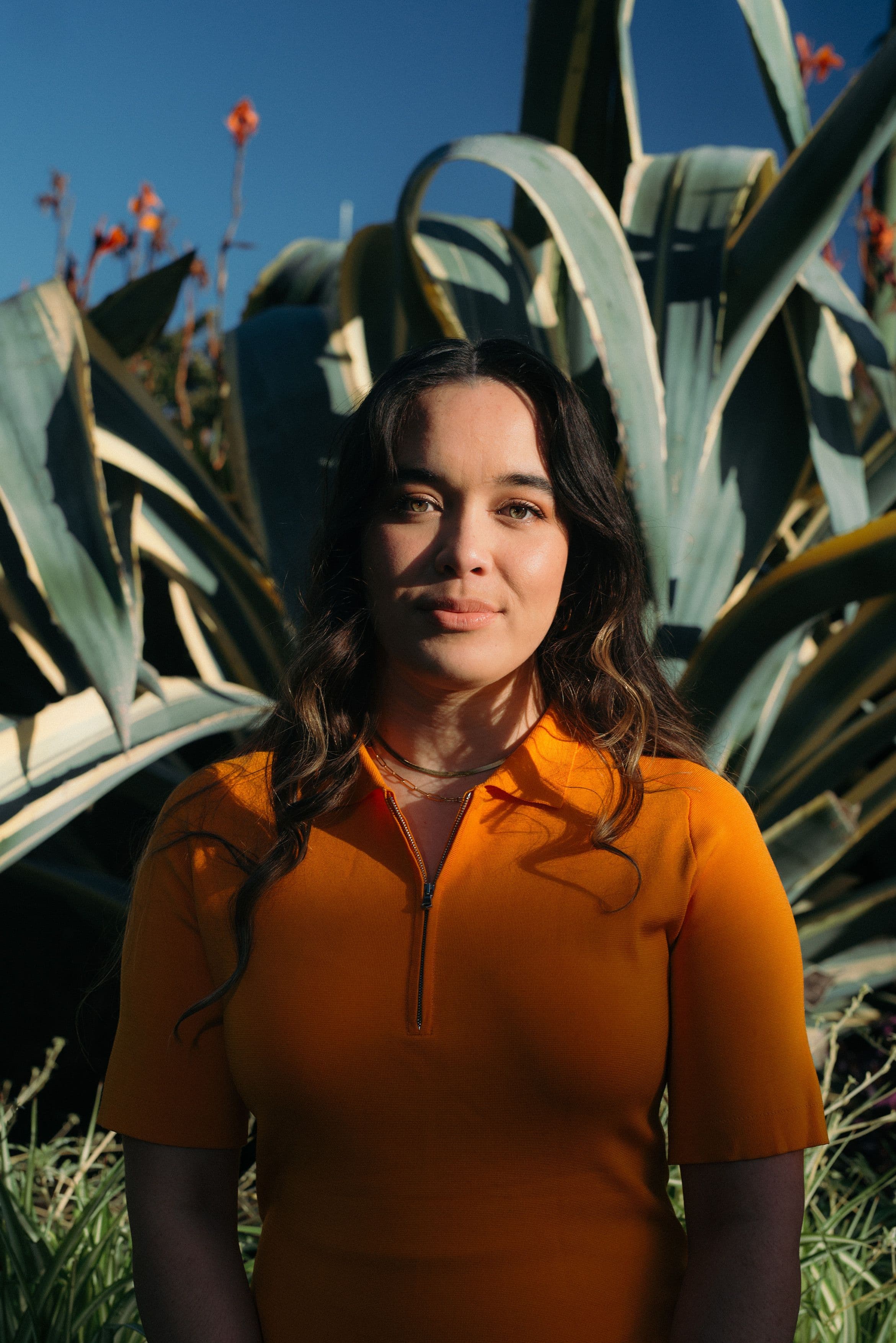 A woman standing in front of a giant plant.