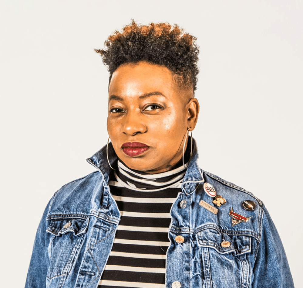 A woman wearing a black and white striped shirt under a denim jacket.