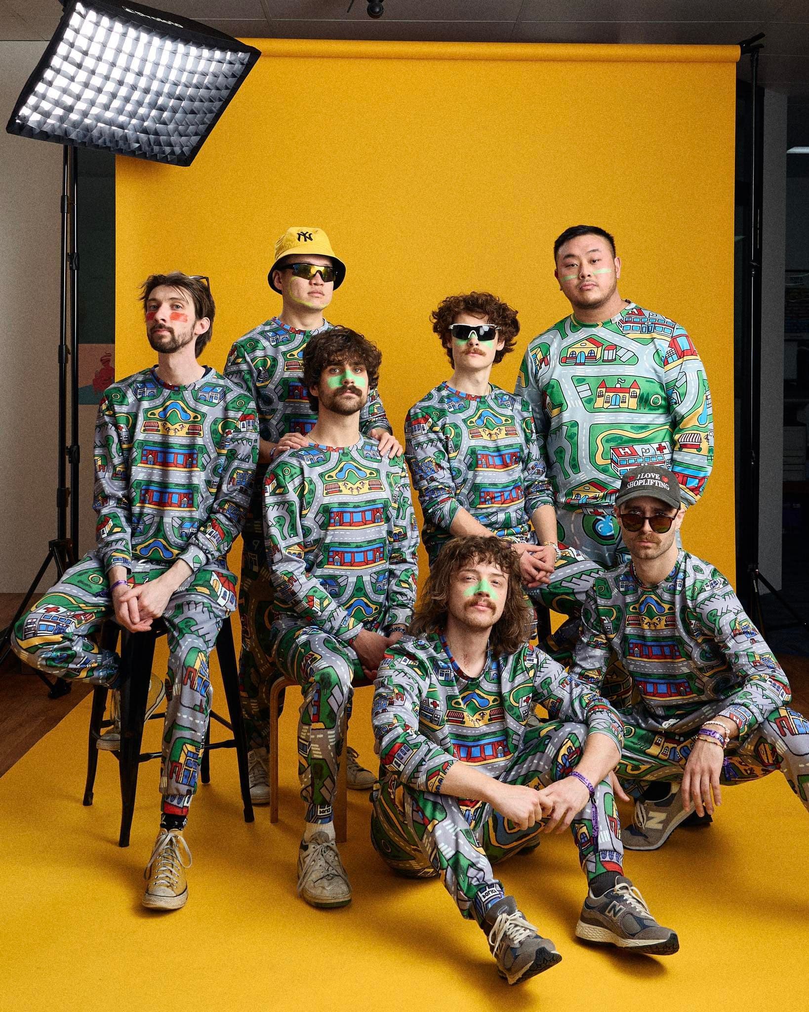 A group of men wearing matching pyjamas having their photo taken in a studio