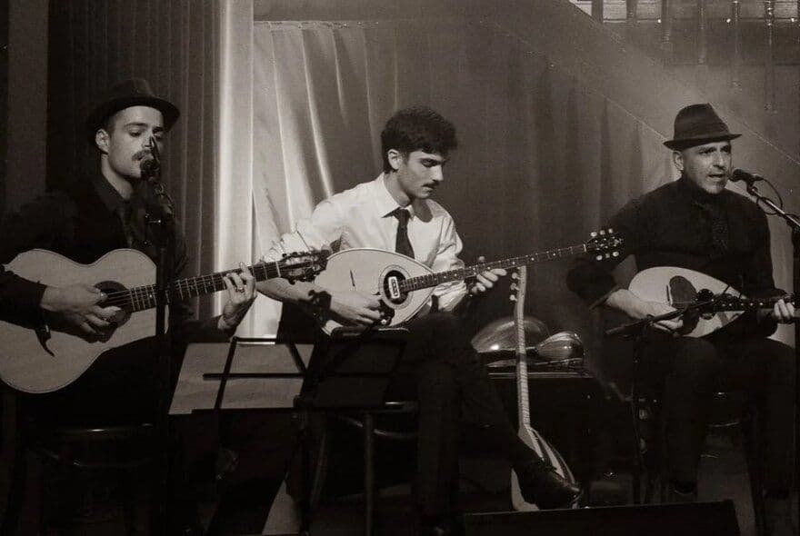 Three men playing instruments together in a classic black and white photograph.