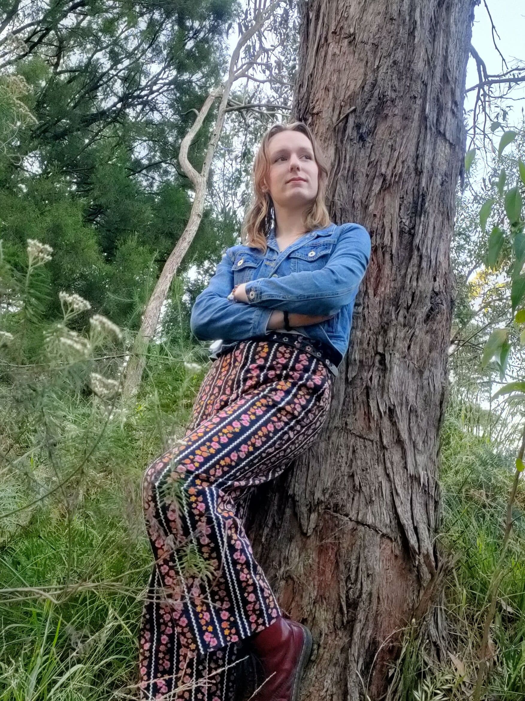 A woman leaning against a tree