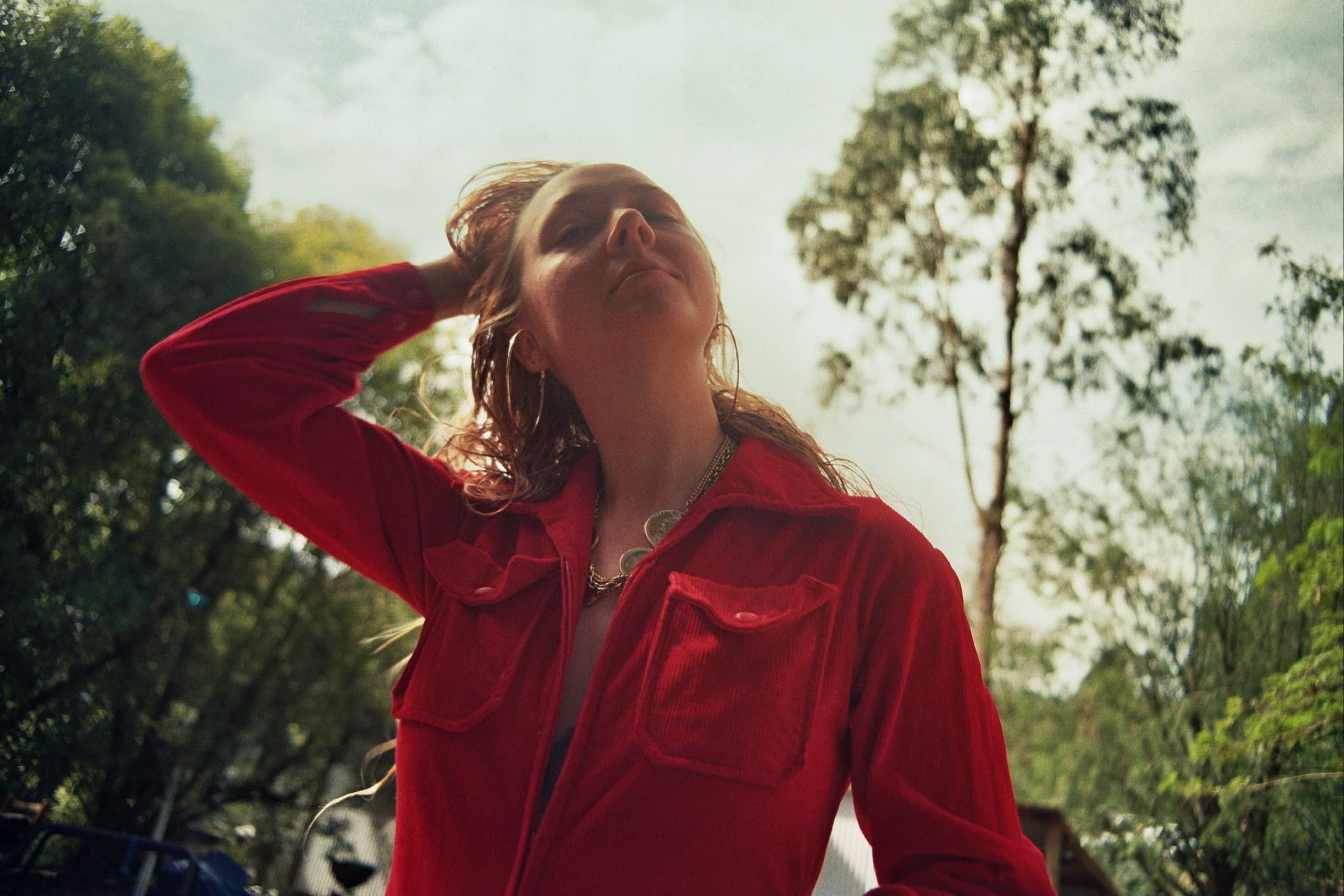 a woman holding her head and standing in the bush
