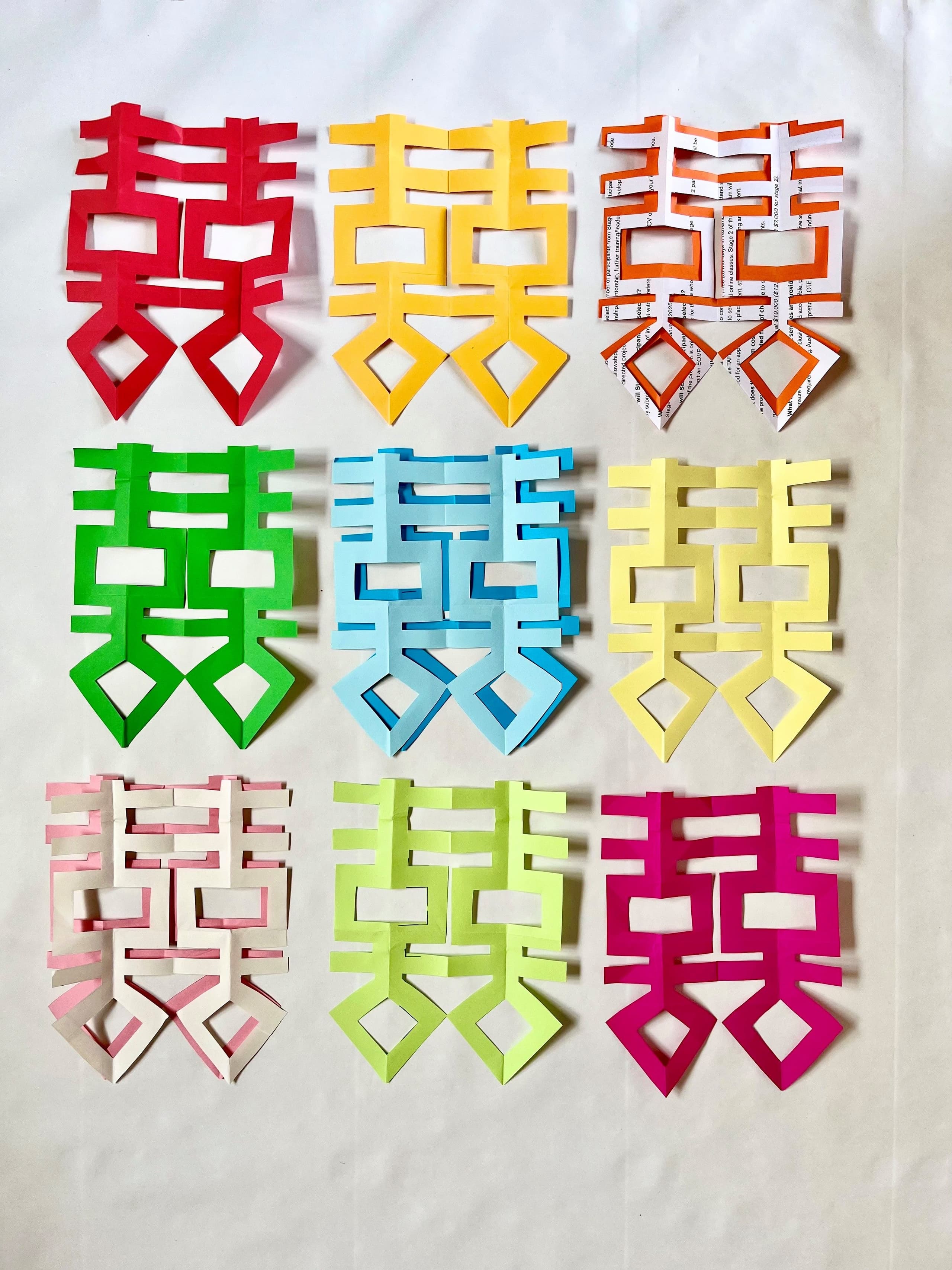 Colorful paper cutouts of various geometric shapes arranged artistically on a flat surface.