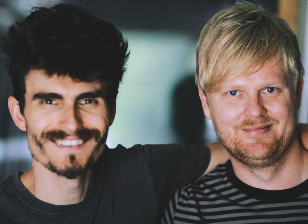 A close up photo of two men smiling at the camera