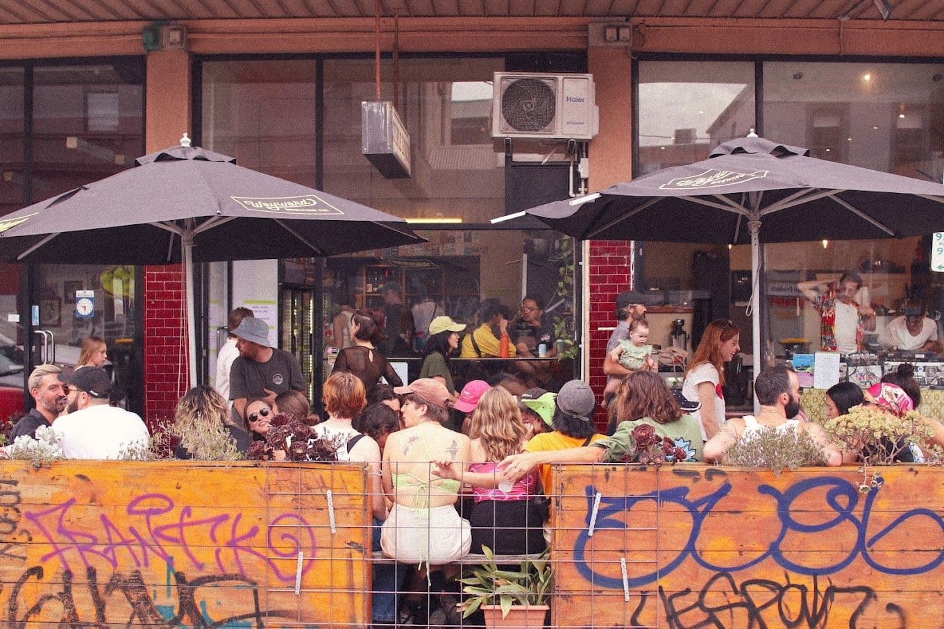 a group of people sitting at tables outside a bar