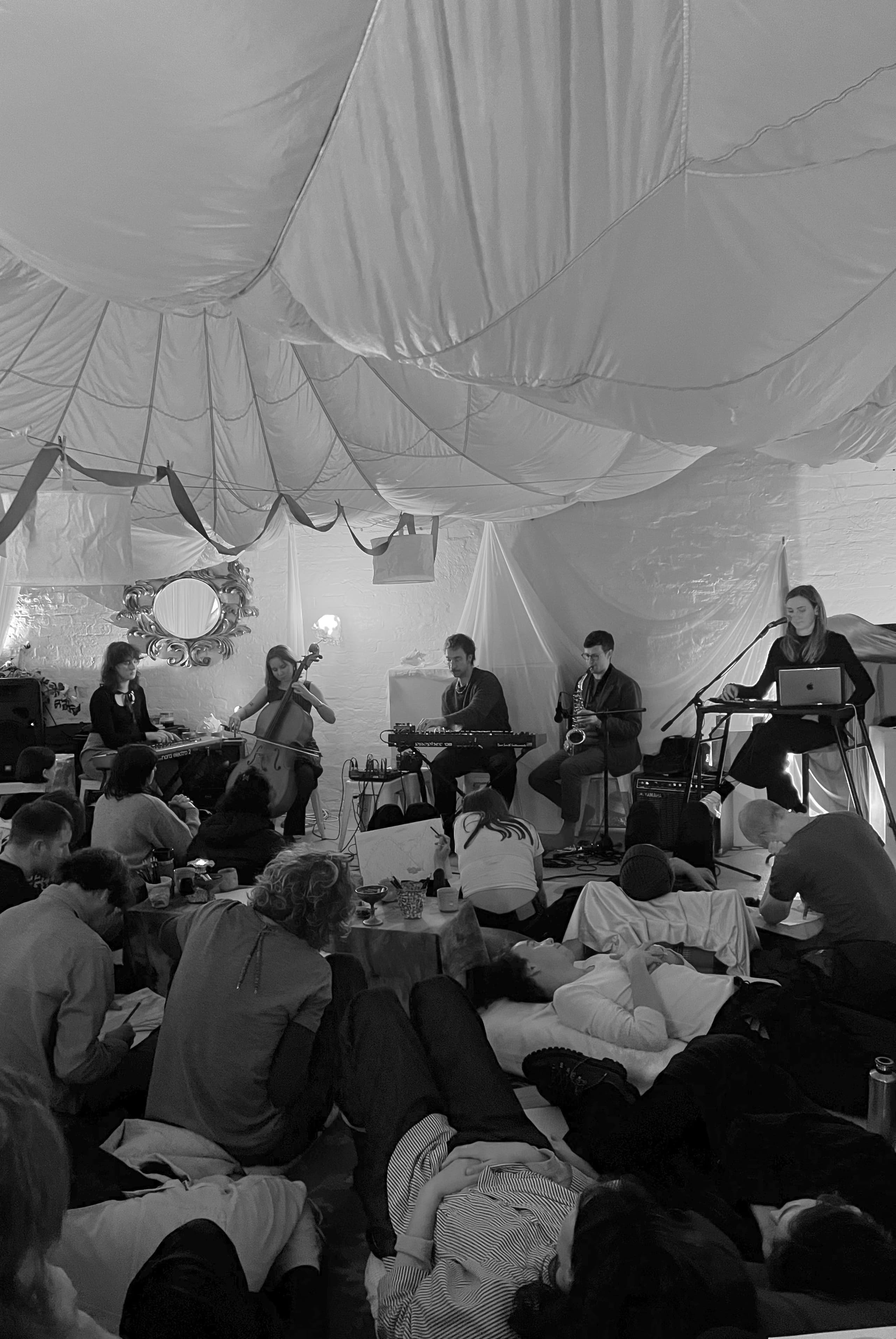A group of people lying down listening to musicians play live
