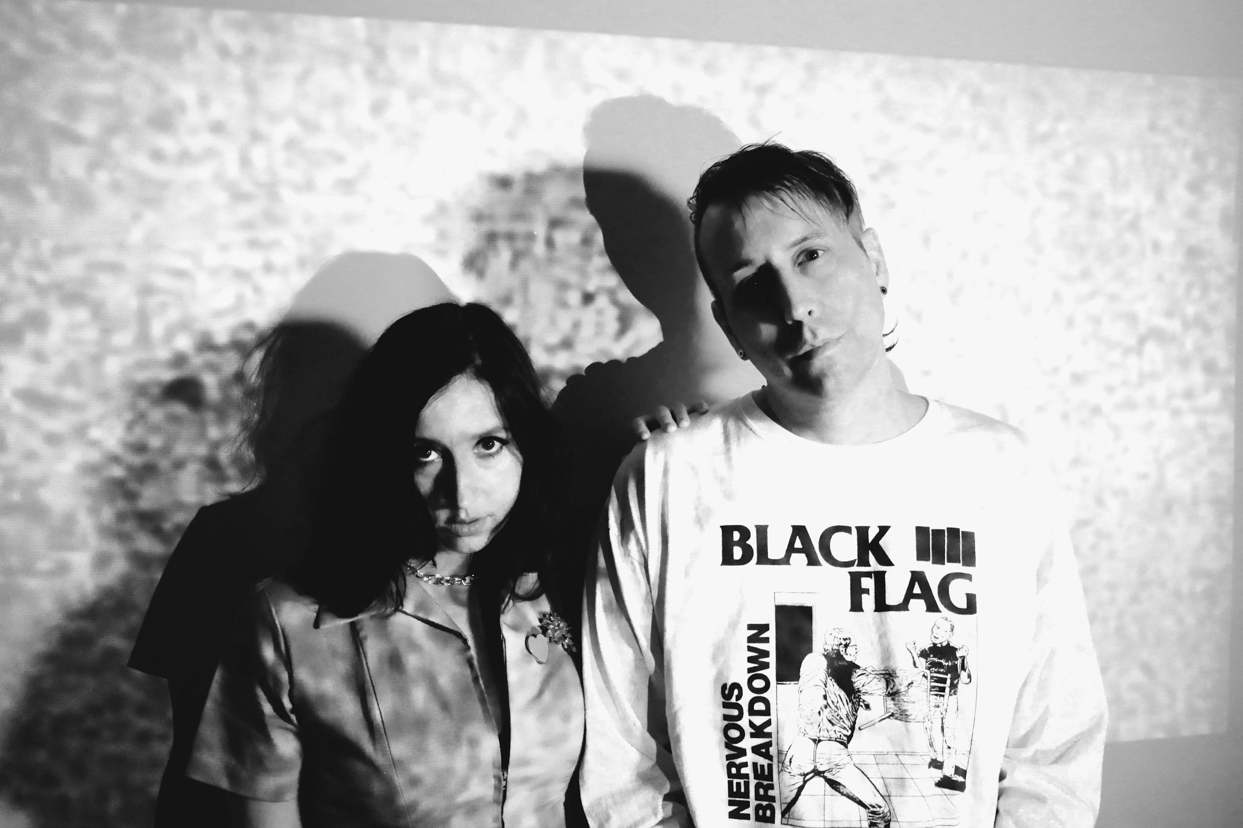 A black and white photo of a man and woman with a projection in the background