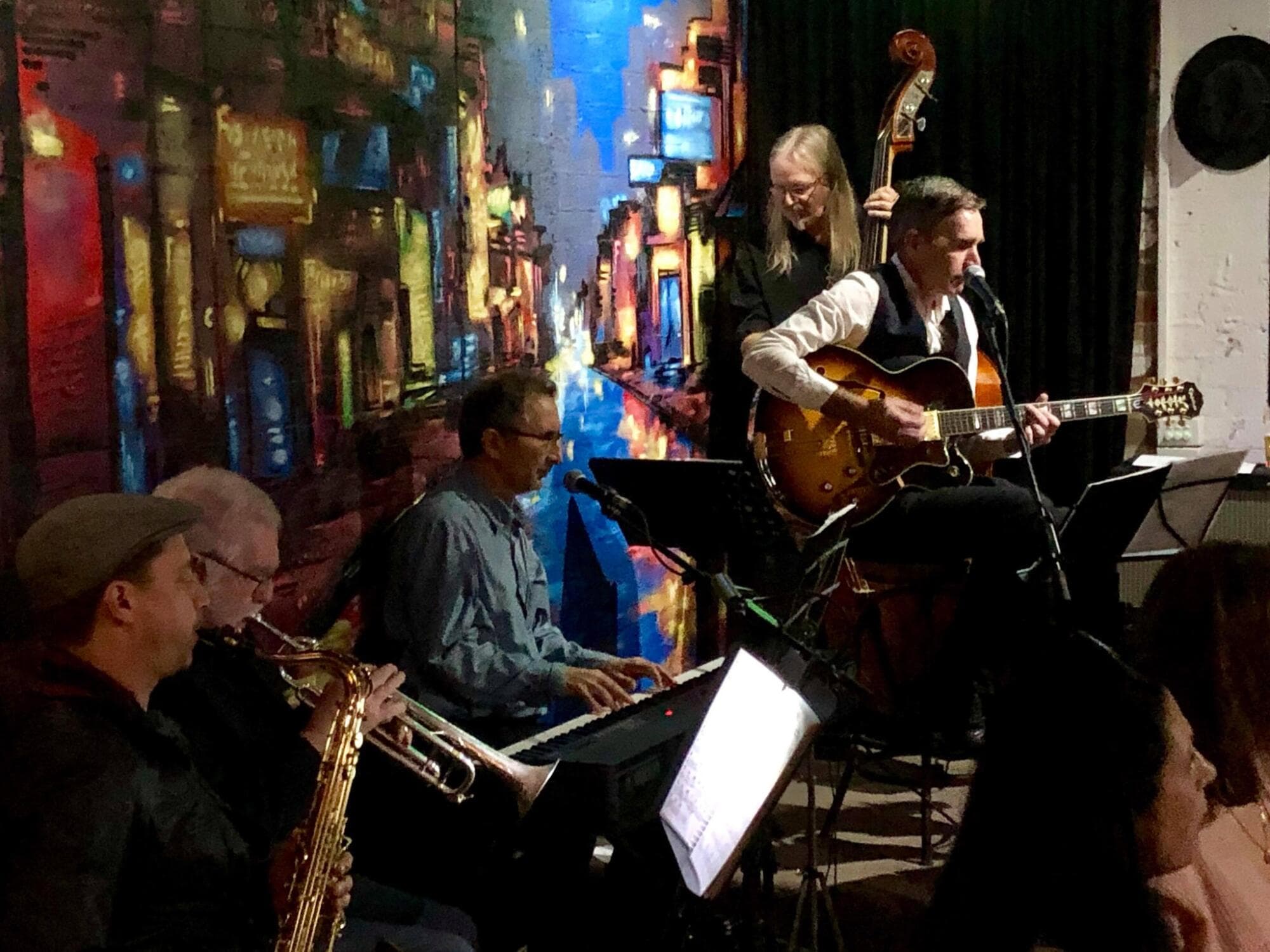 A group of people playing jazz live on stage